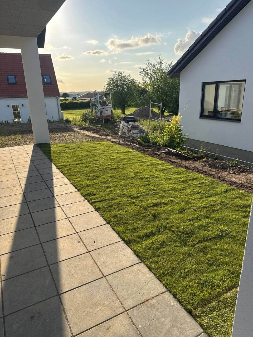 Anlagt græsplæne med stenbelægning og beplantning